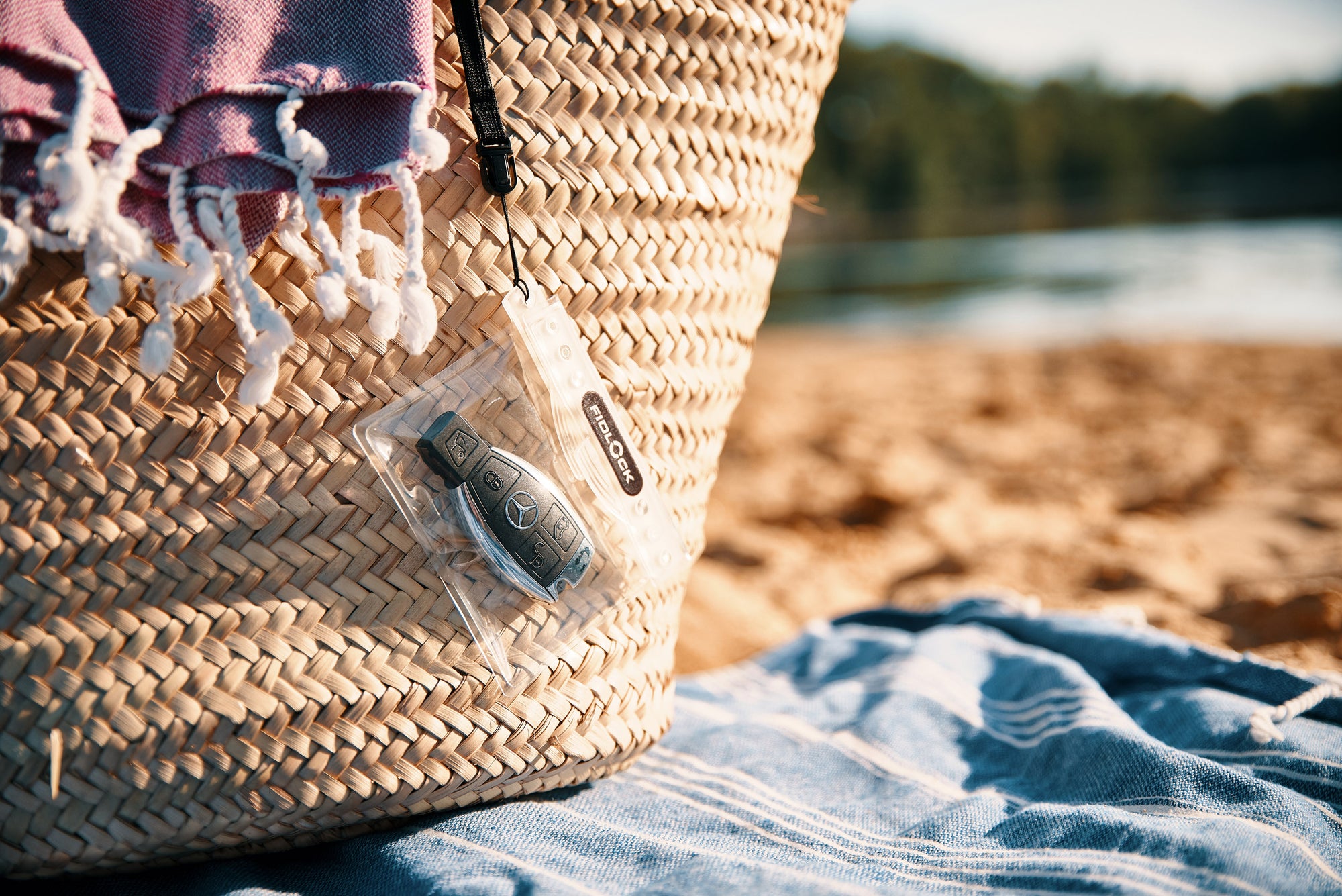 Fidlock hermetic dry bag with car fob key dangling from basket on the beach