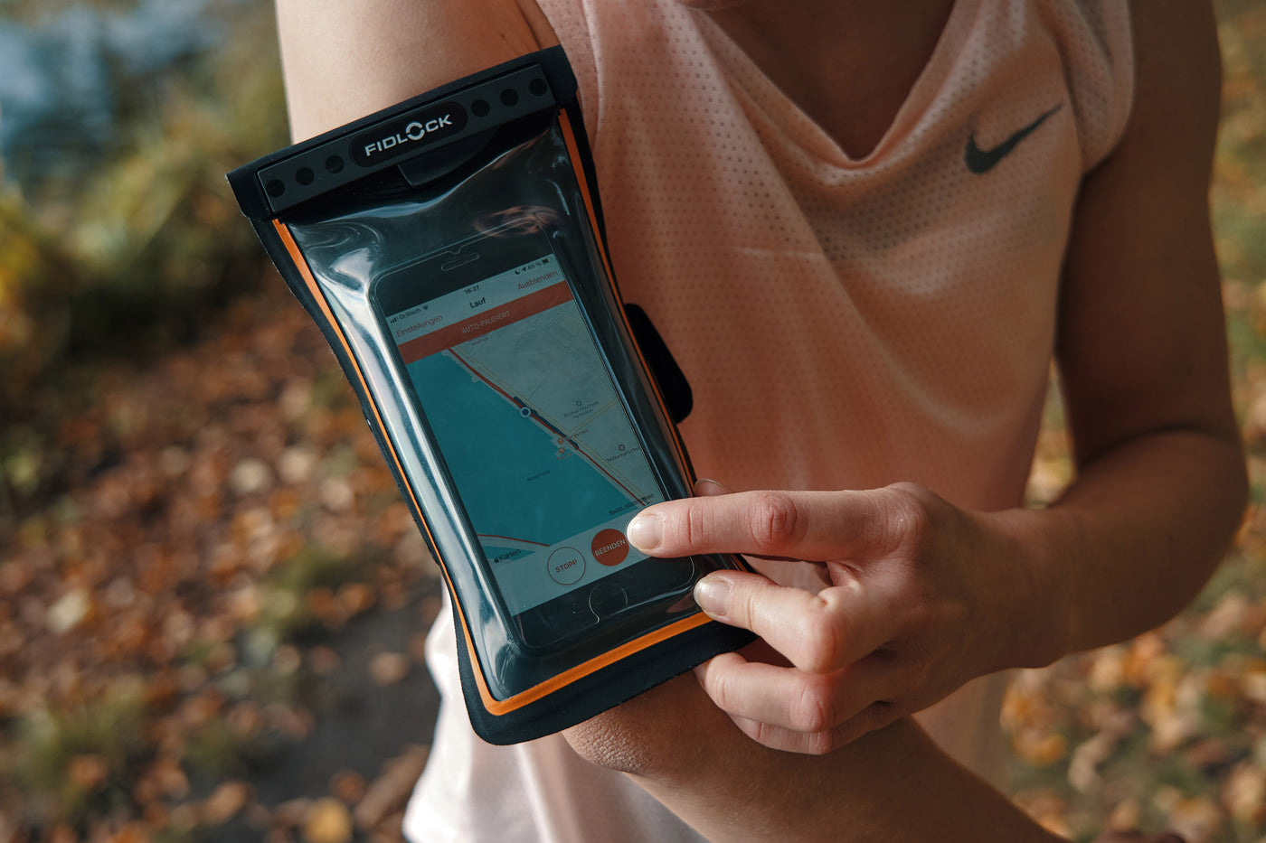 Woman wearing magnetically sealed waterproof armband containing her cell phone