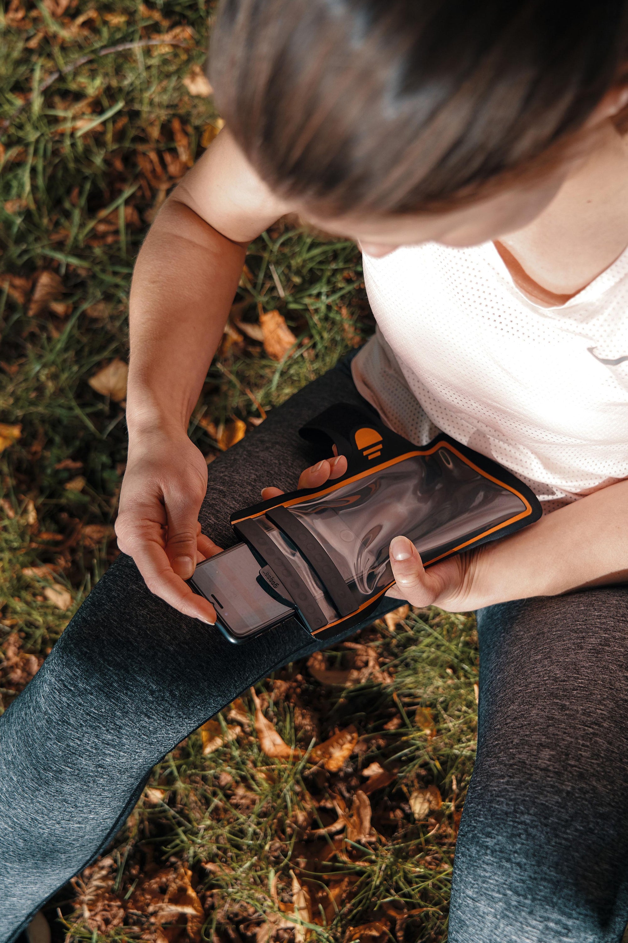 Woman removing phone from Fidlock Arm Band