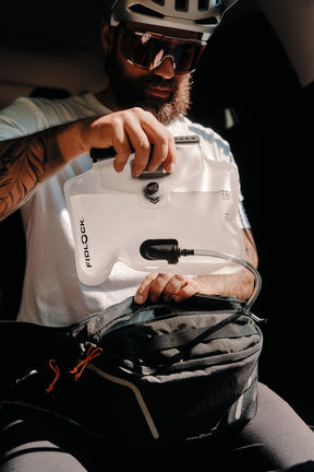 Fidlock hydration bladder being placed inside a Fidlock hip pack
