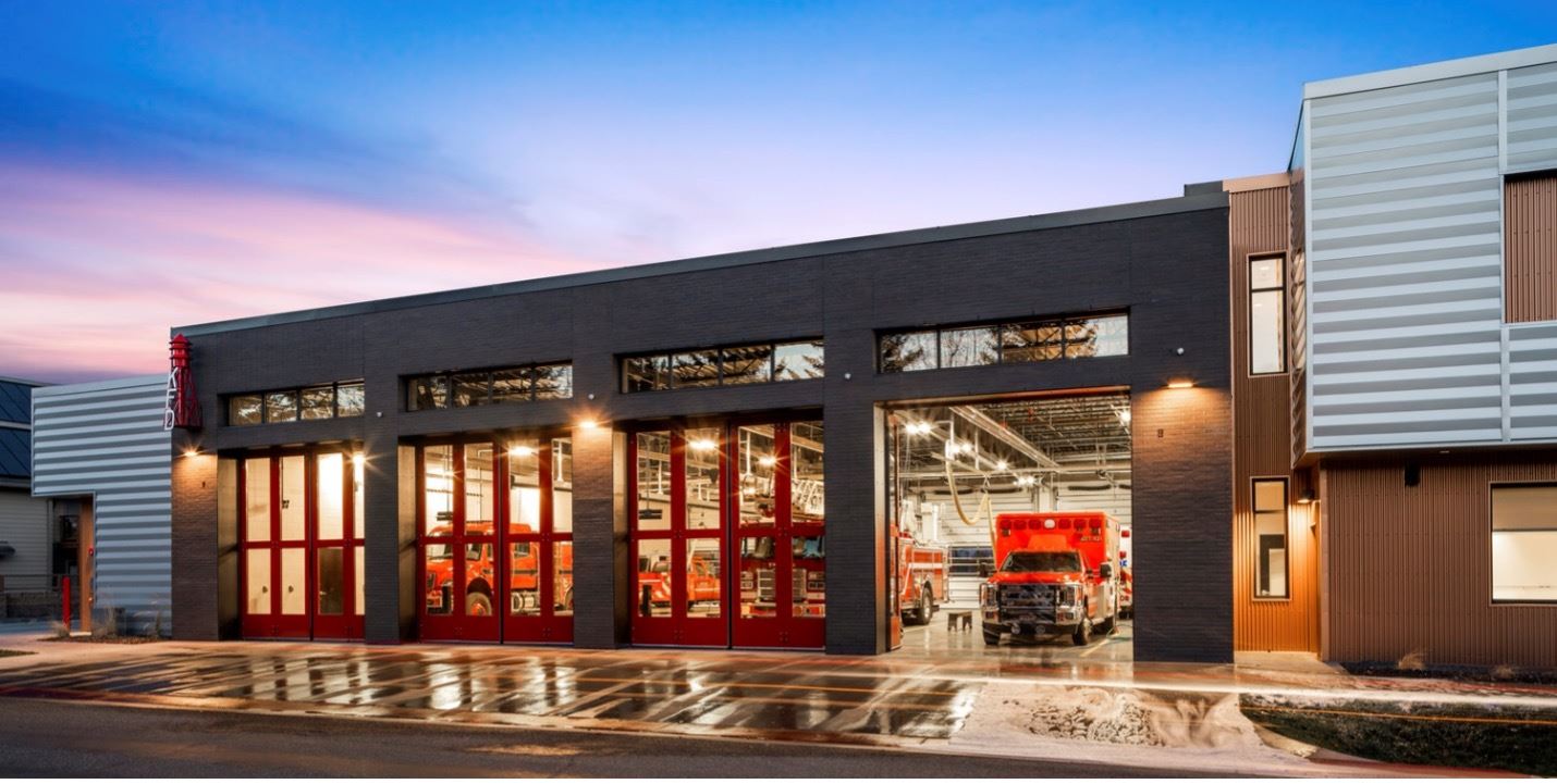 Image of fire station bay doors lit up in the evening